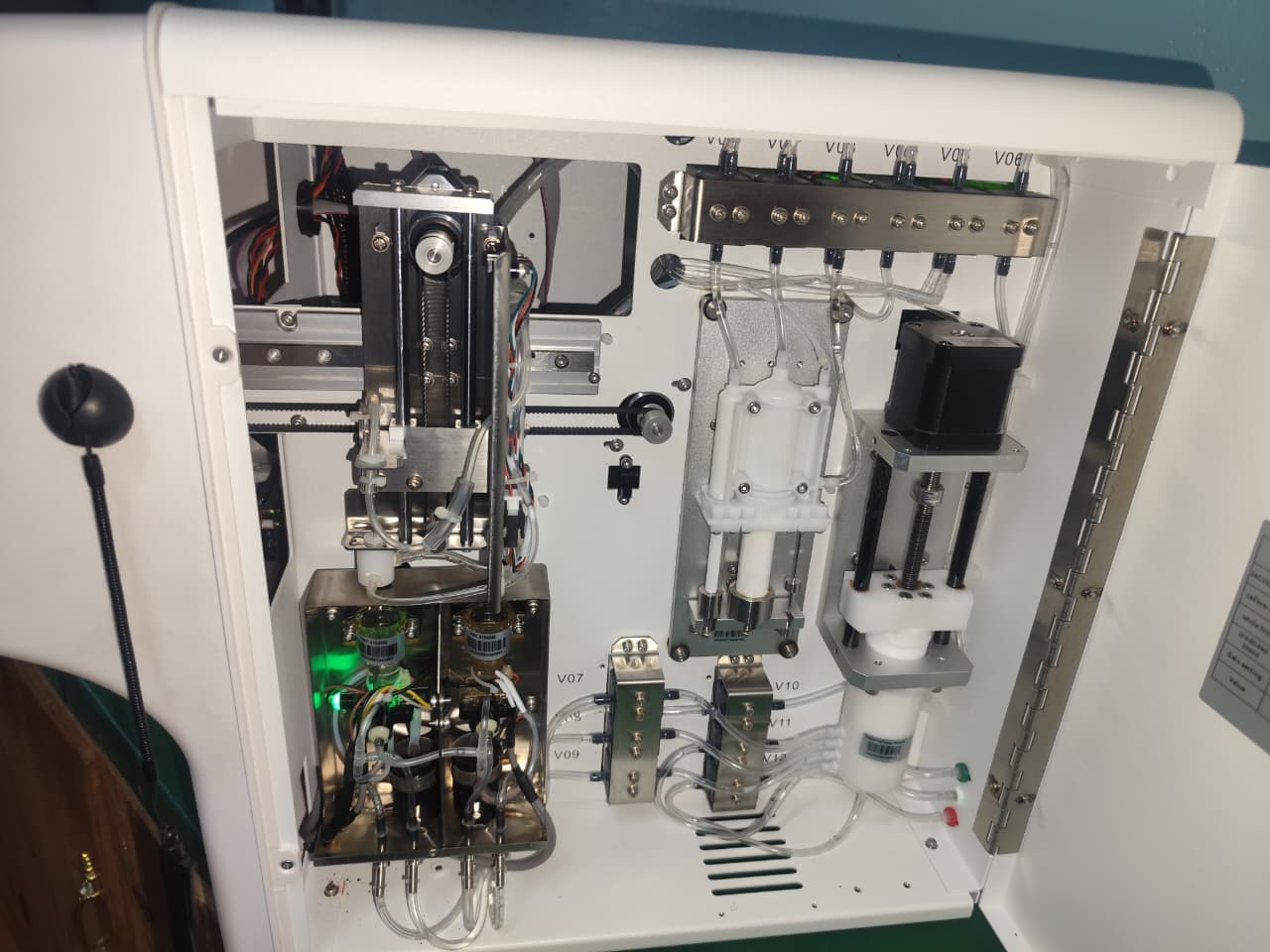 Biomedical technician repairing clinical analyzer internal valves and motor drive mechanism